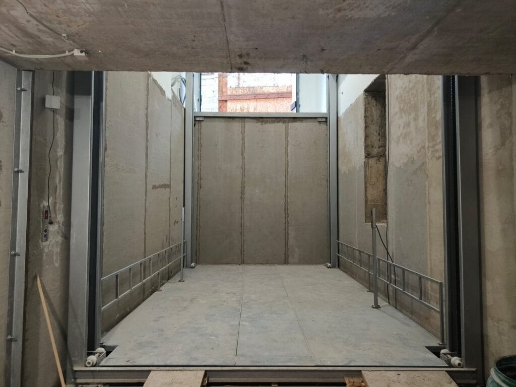 Four post hydraulic vehicle lift platform installed in car dealership