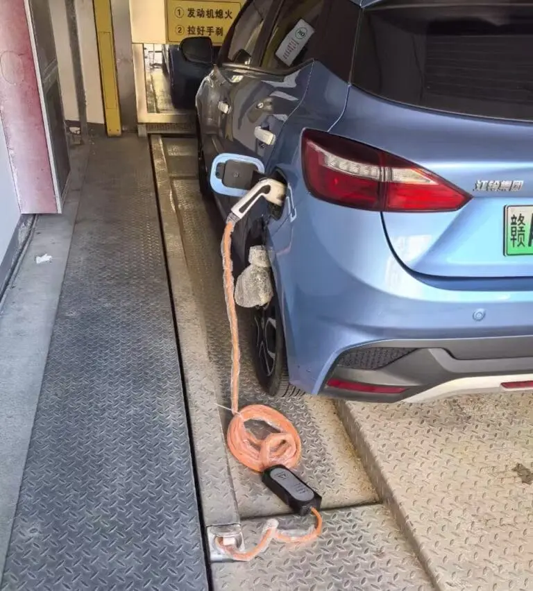 EV charging cable connected to an integrated power socket on an automated parking system pallet
