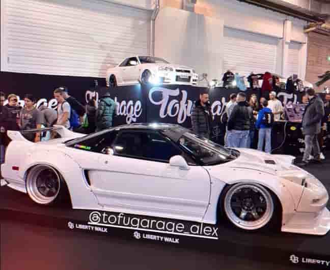 Heavy-duty 4-post car lift showcasing a classic JDM vehicle at a German automotive exhibition by Belecon GmbH Tofugarage.
