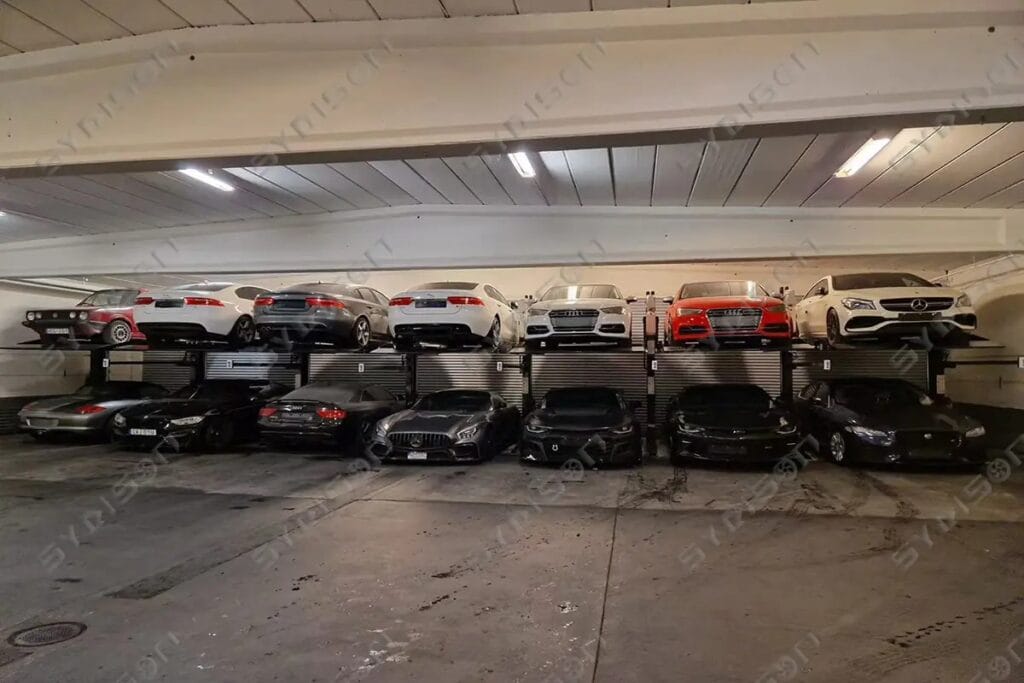 Front wide-angle panoramic view of 9 connected interlocking TPP105 two-post car stacker lifts inside Warg Trading warehouse in Sweden.