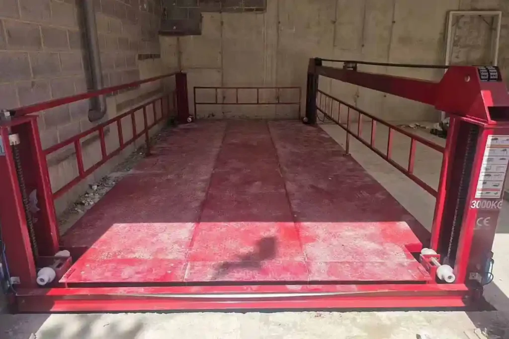 Completed installation of the FPL red car lift between floors installed flush in a UK premium garage showroom